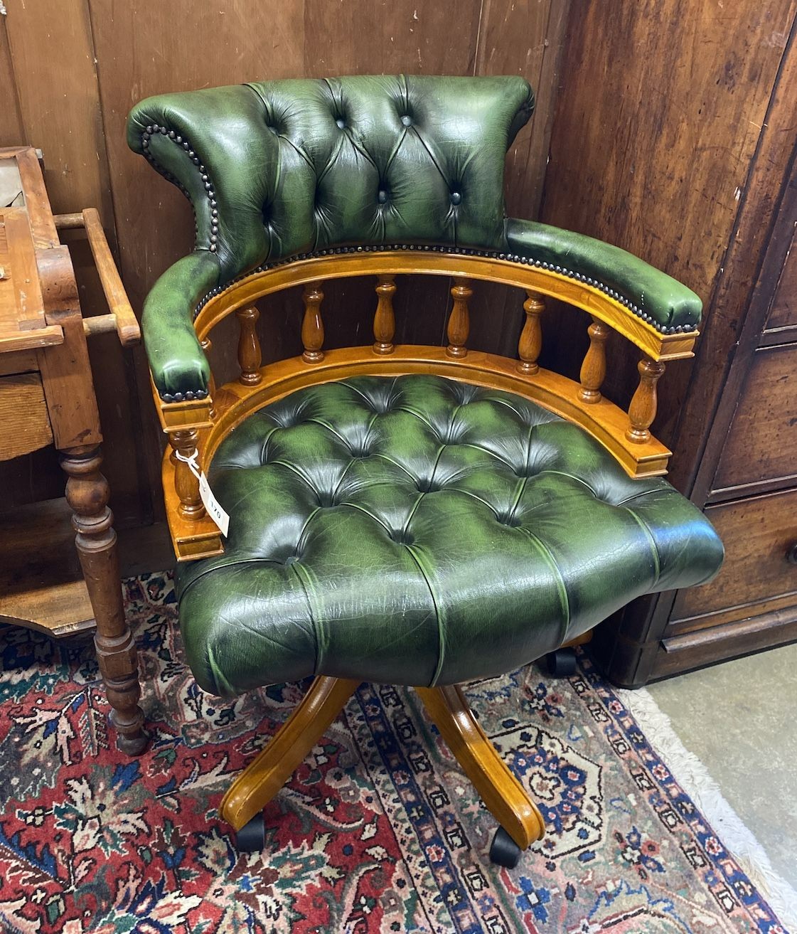 A reproduction buttoned green leather swivel desk chair, width 63cm, depth 57cm, height 84cm